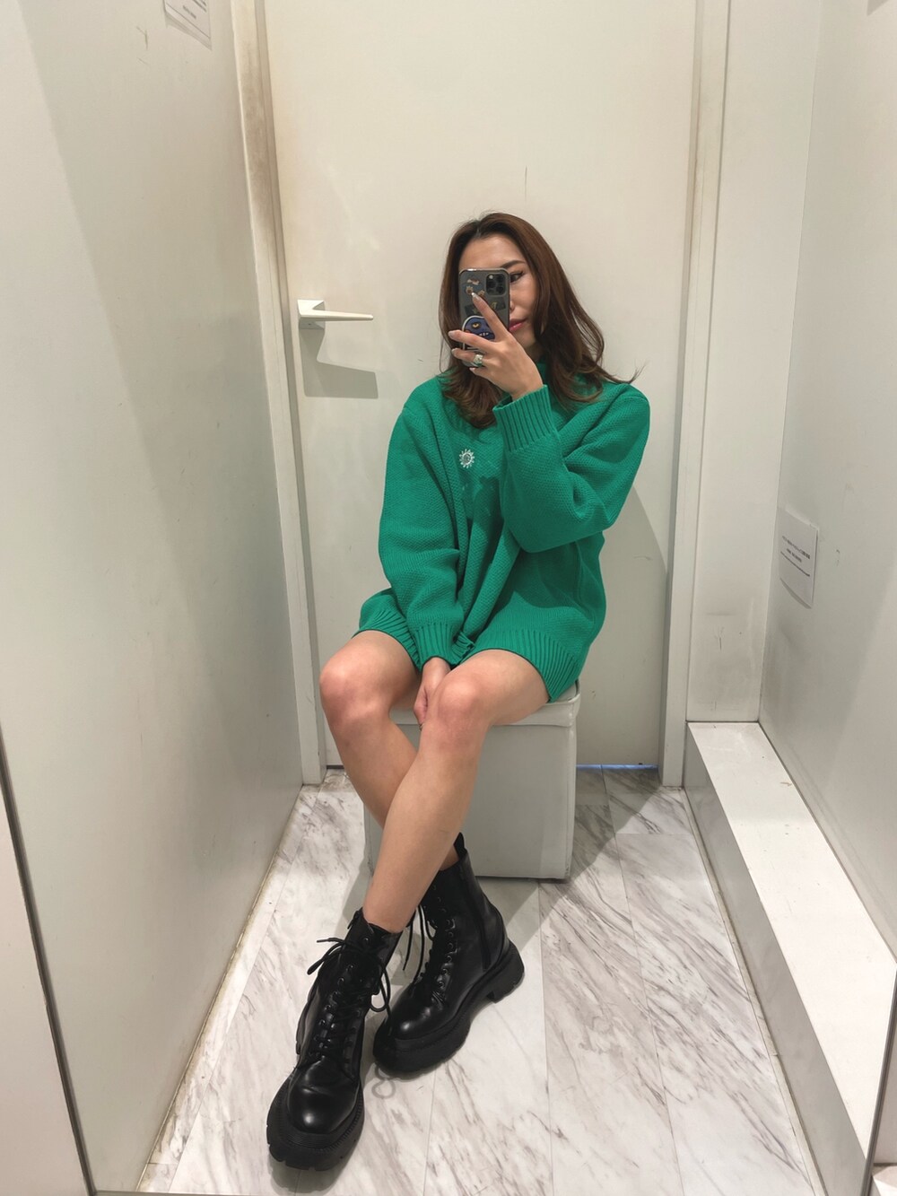 グリーン系のニット/セーター、ブラック系のブーツを着用したレディースの冬コーディネートの3枚目の写真