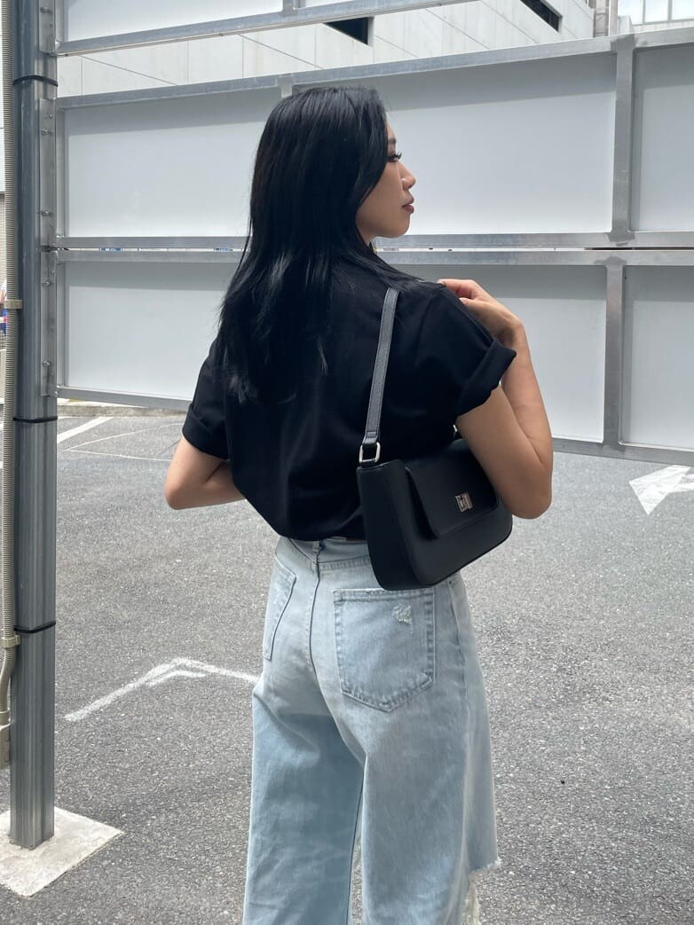 ブラック系のショルダーバッグ、ブルー系のデニムパンツ、ブラック系のTシャツ/カットソーを着用したレディースの夏コーディネートの4枚目の写真