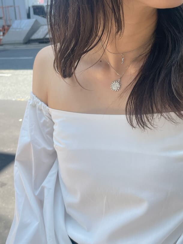 ブラウン系のブーツ、ブラウン系のボストンバッグ、ホワイト系のシャツ/ブラウスを着用したレディースの秋コーディネートの6枚目の写真