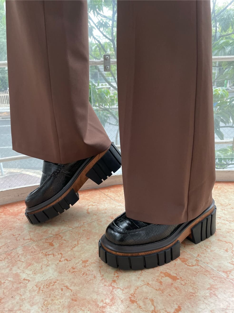 ブラック系のローファー、ブラック系のハンドバッグ、ホワイト系のTシャツ/カットソーを着用したレディースの夏コーディネートの8枚目の写真