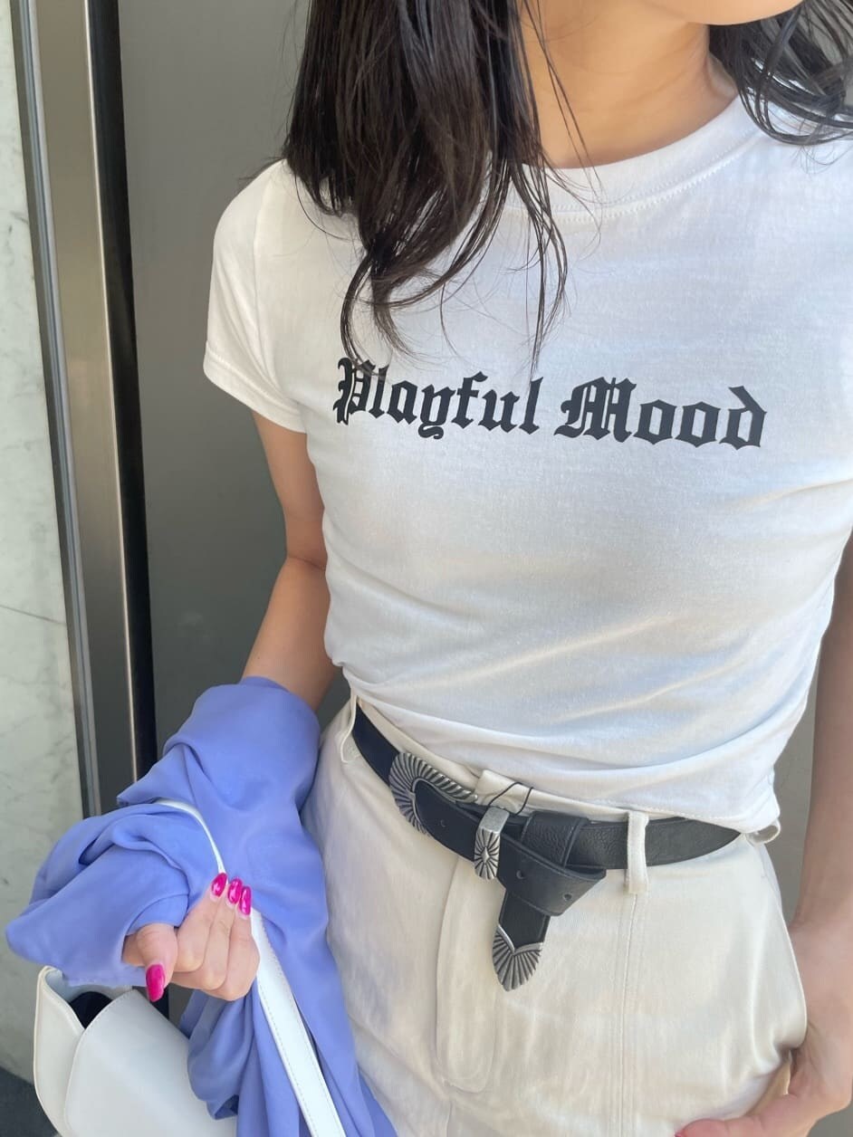 ホワイト系のTシャツ/カットソー、ホワイト系のスカート、ホワイト系のサンダルを着用したレディースの春コーディネートの5枚目の写真