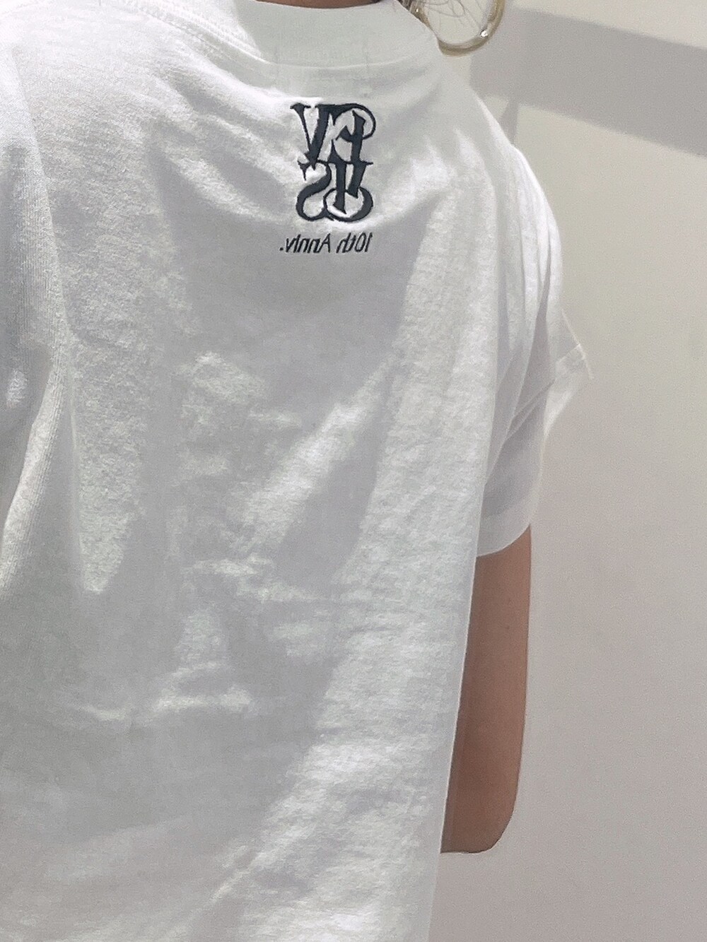 ホワイト系のTシャツ/カットソー、ブルー系のデニムパンツ、ブラック系のサンダルを着用したレディースの春コーディネートの5枚目の写真