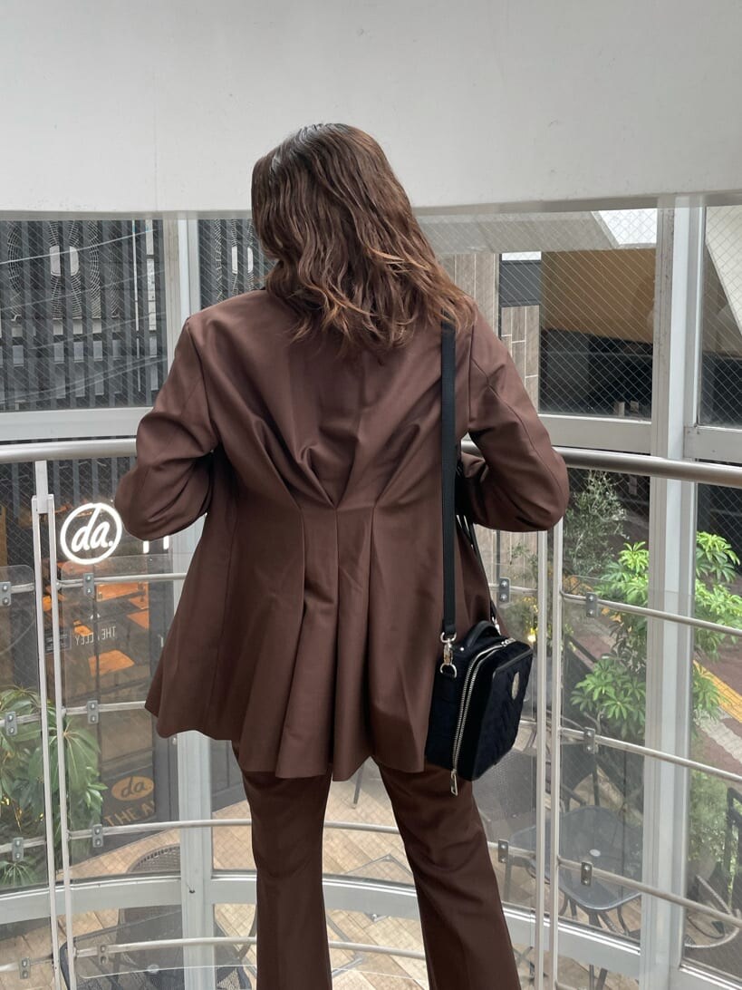 ブラック系のローファー、ブラック系のハンドバッグ、ホワイト系のTシャツ/カットソーを着用したレディースの夏コーディネートの5枚目の写真