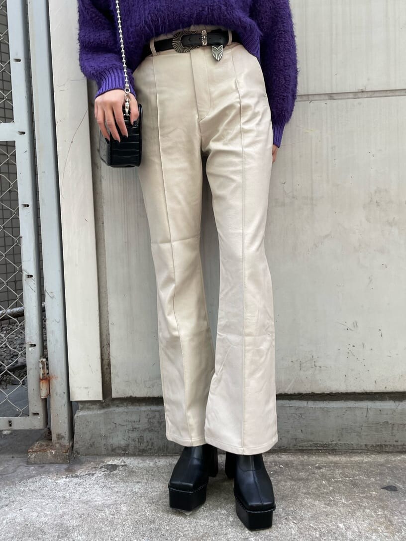 ブラック系のブーツ、パープル系のニット/セーター、ブラック系のショルダーバッグを着用したレディースの冬コーディネートの6枚目の写真