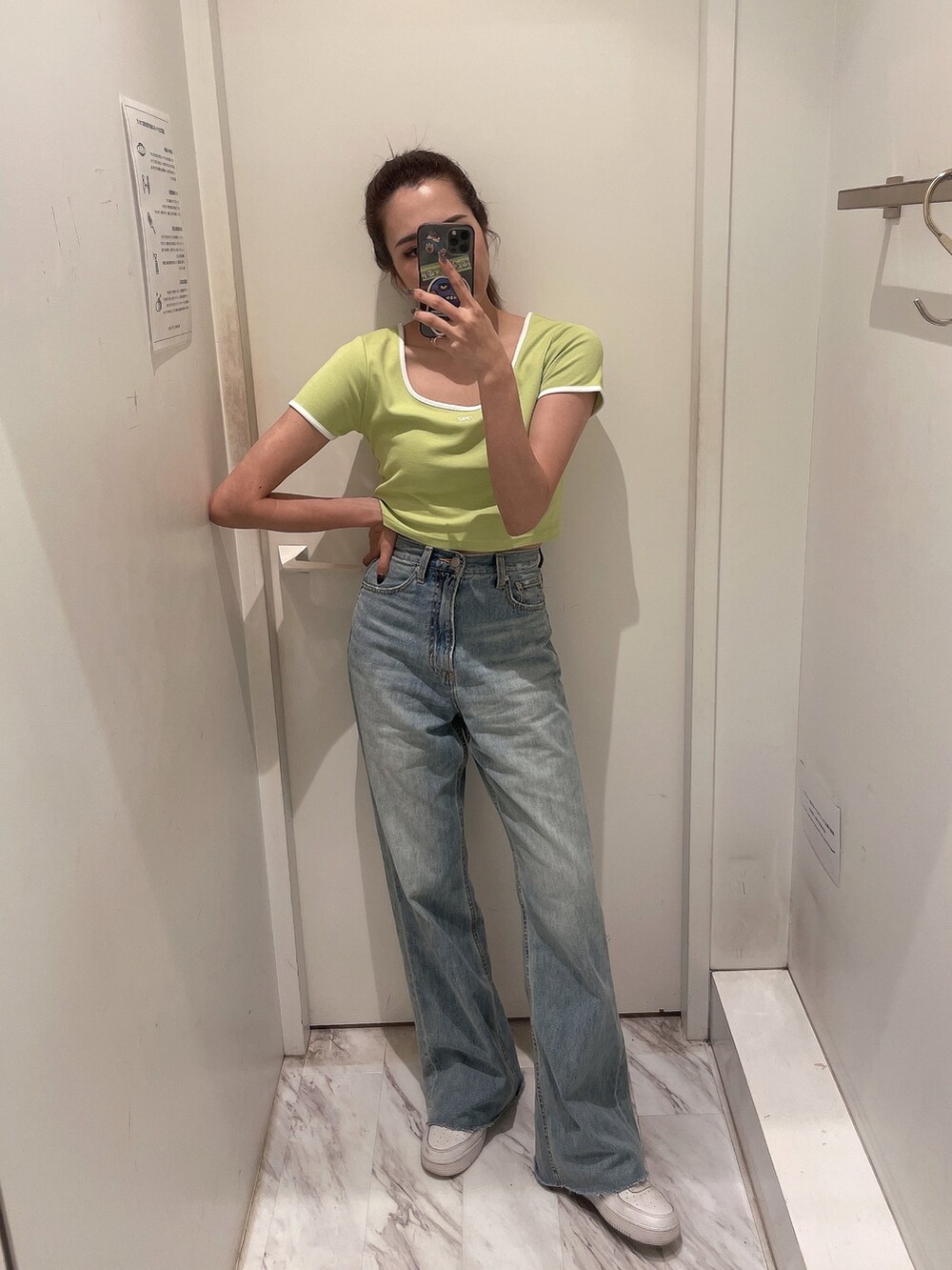 グリーン系のTシャツ/カットソー、ブルー系のデニムパンツを着用したレディースの春コーディネートの4枚目の写真