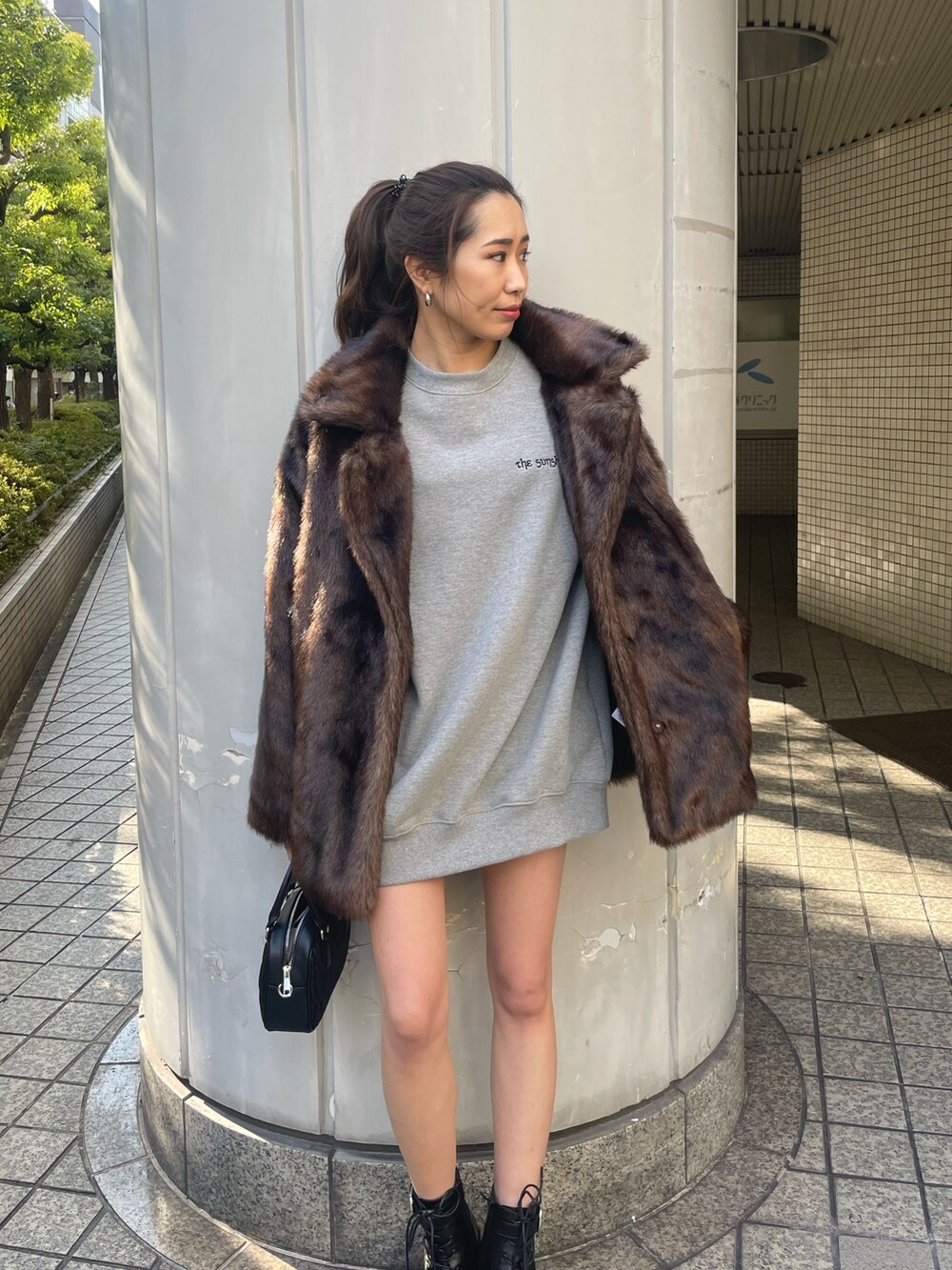 グレー系のスウェット、ブラック系のショルダーバッグ、ブラック系のブーツを着用したレディースの冬コーディネートの3枚目の写真