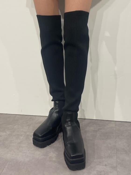 ブラウン系のワンピース、ブラック系のブーツ、ブラック系のショルダーバッグを着用したレディースの秋コーディネートの7枚目の写真