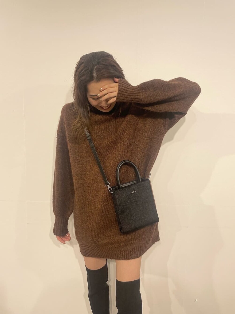 ブラウン系のワンピース、ブラック系のブーツ、ブラック系のショルダーバッグを着用したレディースの秋コーディネートの3枚目の写真