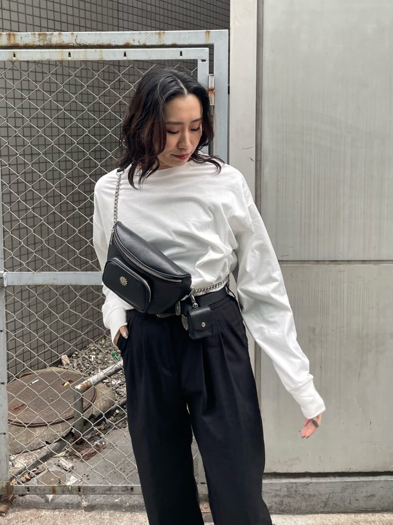 ブラック系のボディバッグ/ウエストポーチ、ブラック系のブーツ、ホワイト系のTシャツ/カットソーを着用したレディースの冬コーディネートの4枚目の写真