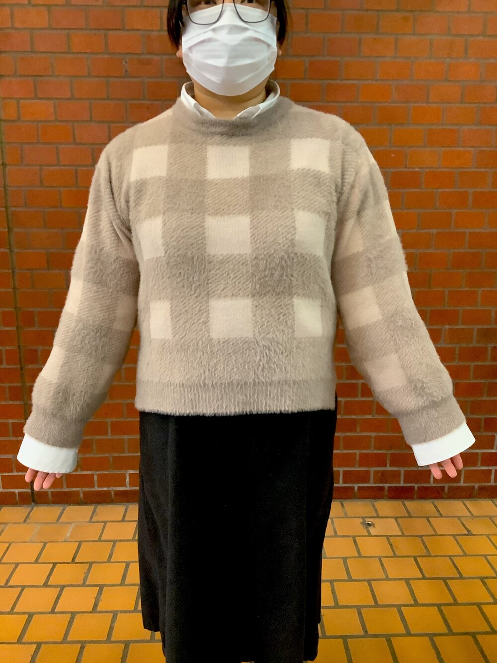 ブラウン系のニット/セーターを着用したレディースの冬コーディネートの2枚目の写真