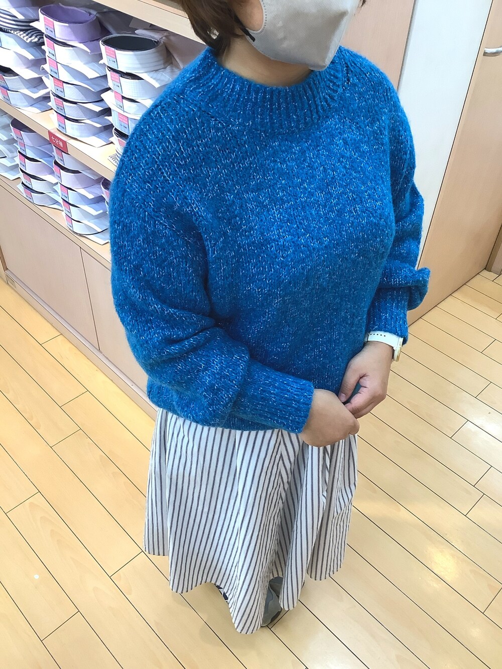 ブルー系のニット/セーターを着用したレディースの冬コーディネートの2枚目の写真