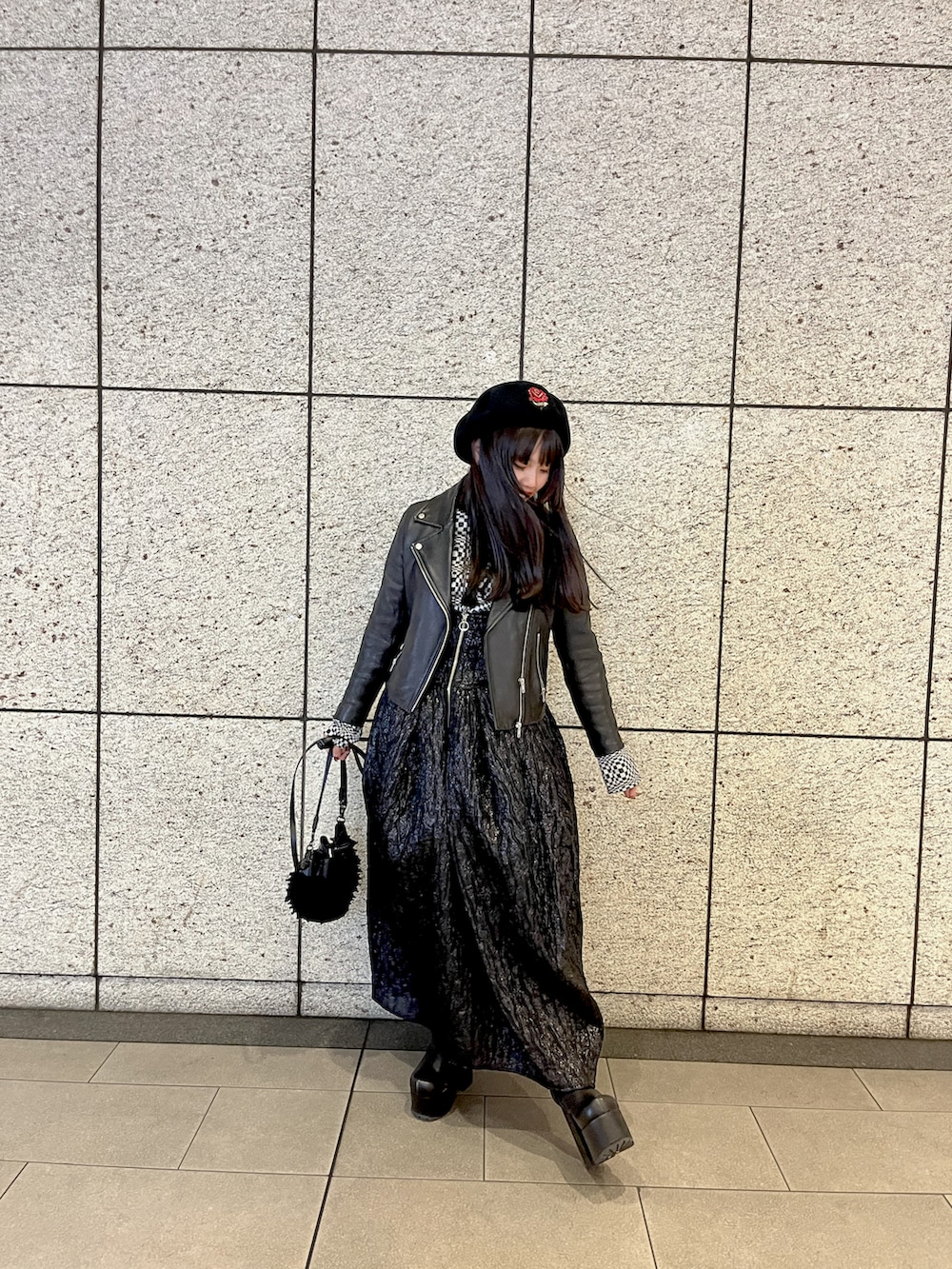 ブラック系のライダースジャケット、ブラック系のジャンパースカート、ブラック系のブーツを着用したレディースの冬コーディネートの2枚目の写真