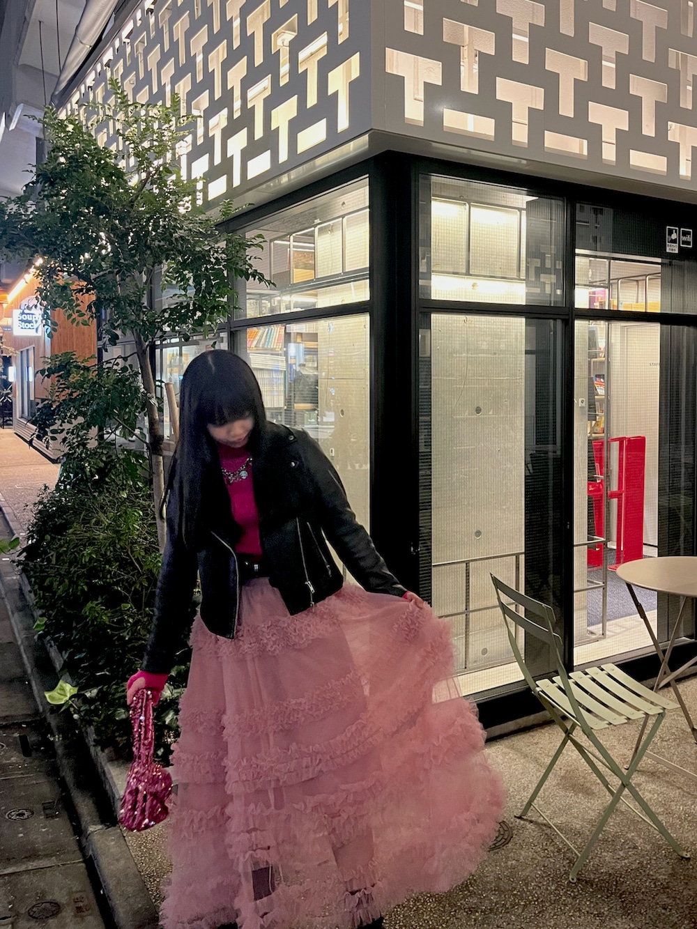 ピンク系のニット/セーター、ブラック系のライダースジャケット、ピンク系のハンドバッグを着用したレディースの冬コーディネートの2枚目の写真