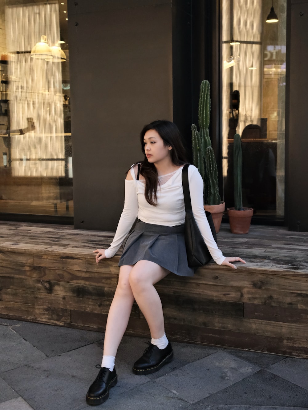 ホワイト系のTシャツ/カットソー、グレー系のスカート、ブラック系のトートバッグを着用したレディースの冬コーディネートの2枚目の写真