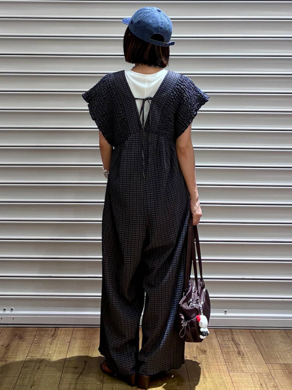ホワイト系のTシャツ/カットソー、グリーン系のサロペット/オーバーオール、ブラウン系のサンダルを着用したレディースの夏コーディネートの2枚目の写真