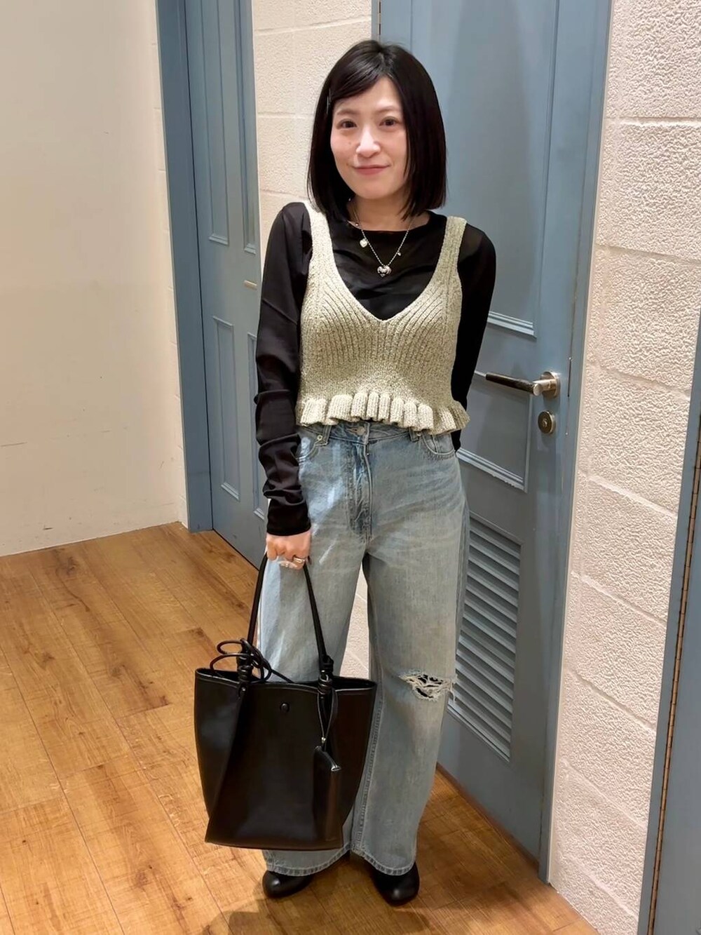 ブラック系のTシャツ/カットソー、ブルー系のデニムパンツ、ブラック系のサンダルを着用したレディースの春コーディネートの4枚目の写真
