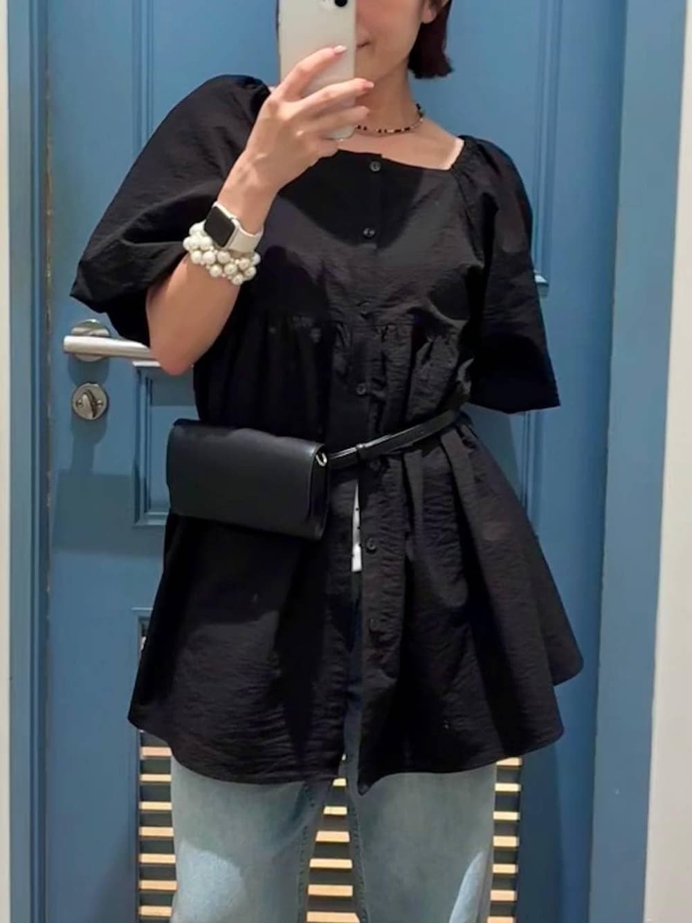 ブルー系のデニムパンツ、ブラック系のボディバッグ/ウエストポーチ、ブラック系のシャツ/ブラウスを着用したレディースの夏コーディネートの2枚目の写真