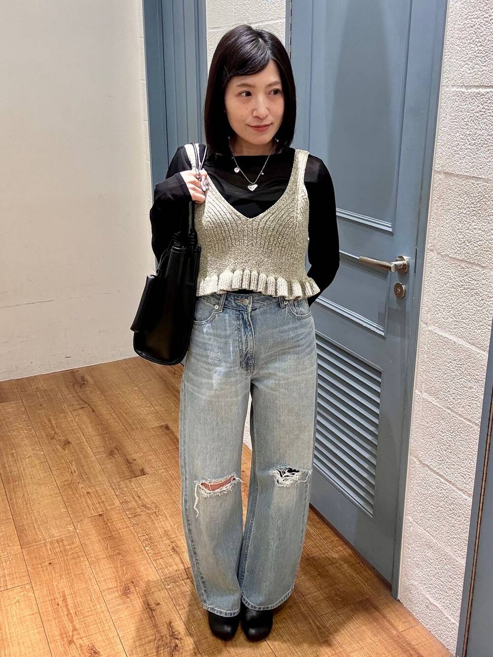 ブラック系のTシャツ/カットソー、ブルー系のデニムパンツ、ブラック系のサンダルを着用したレディースの春コーディネートの2枚目の写真