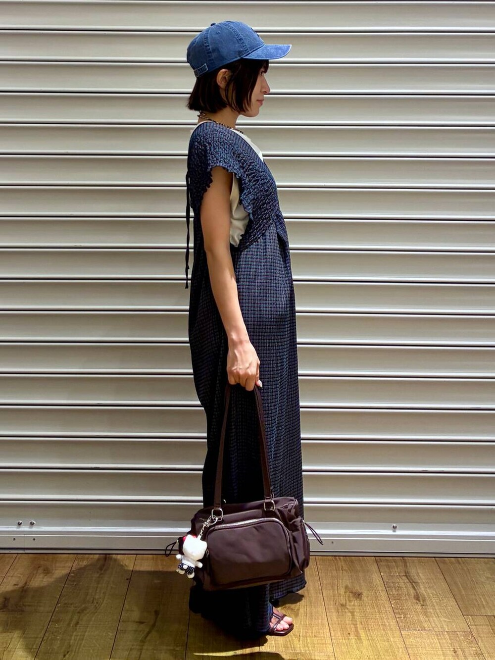 ホワイト系のTシャツ/カットソー、グリーン系のサロペット/オーバーオール、ブラウン系のサンダルを着用したレディースの夏コーディネートの4枚目の写真