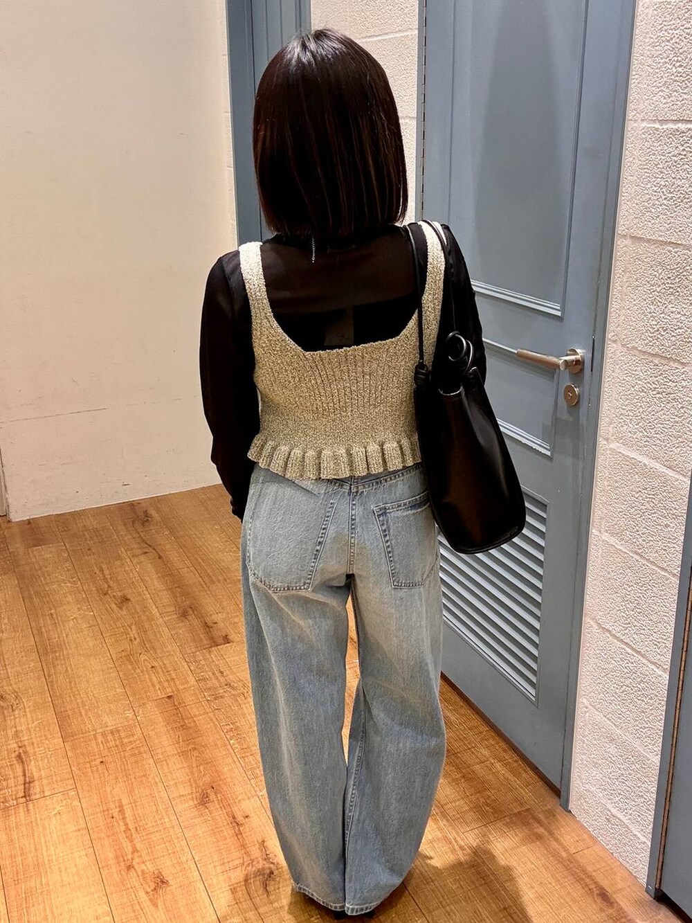 ブラック系のTシャツ/カットソー、ブルー系のデニムパンツ、ブラック系のサンダルを着用したレディースの春コーディネートの5枚目の写真