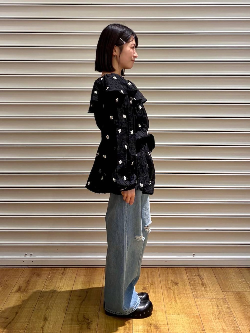 ブルー系のデニムパンツ、ブラック系のサンダル、ブラック系のボディバッグ/ウエストポーチを着用したレディースの春コーディネートの4枚目の写真