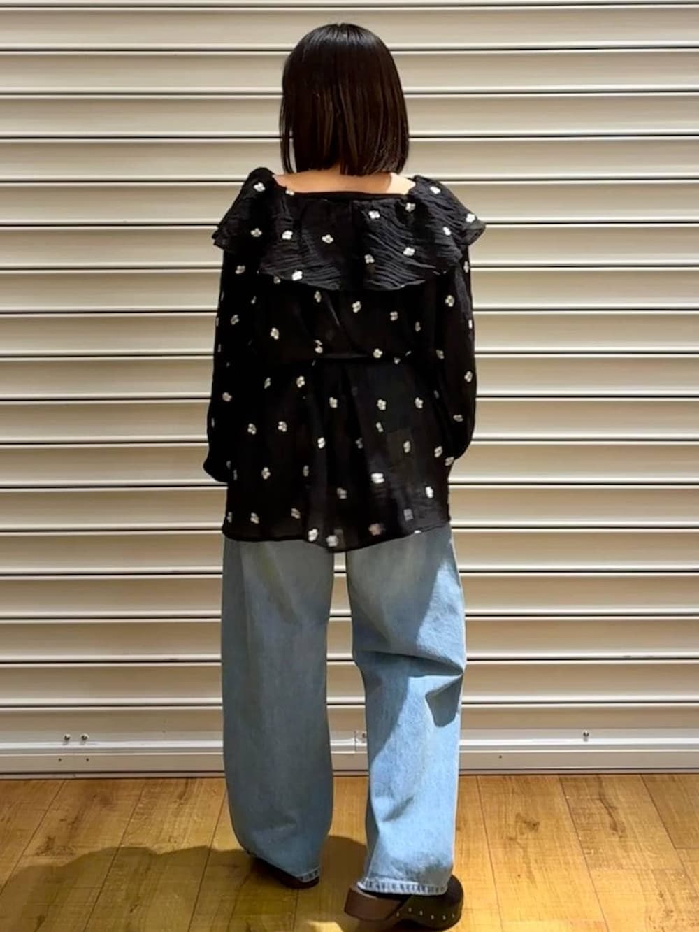 ブルー系のデニムパンツ、ブラック系のサンダル、ブラック系のボディバッグ/ウエストポーチを着用したレディースの春コーディネートの5枚目の写真