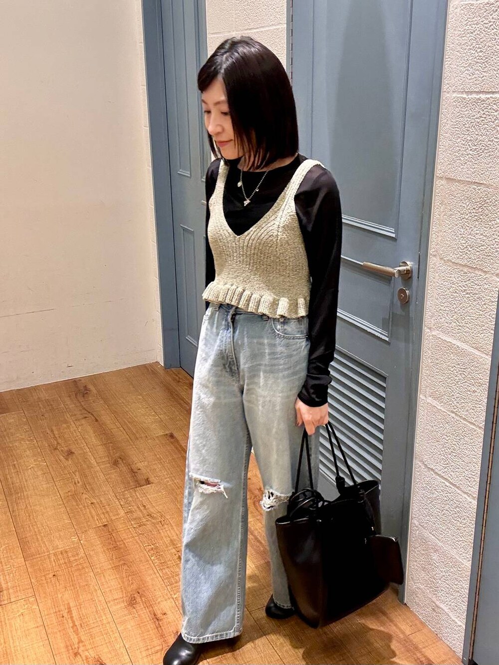 ブラック系のTシャツ/カットソー、ブルー系のデニムパンツ、ブラック系のサンダルを着用したレディースの春コーディネートの6枚目の写真