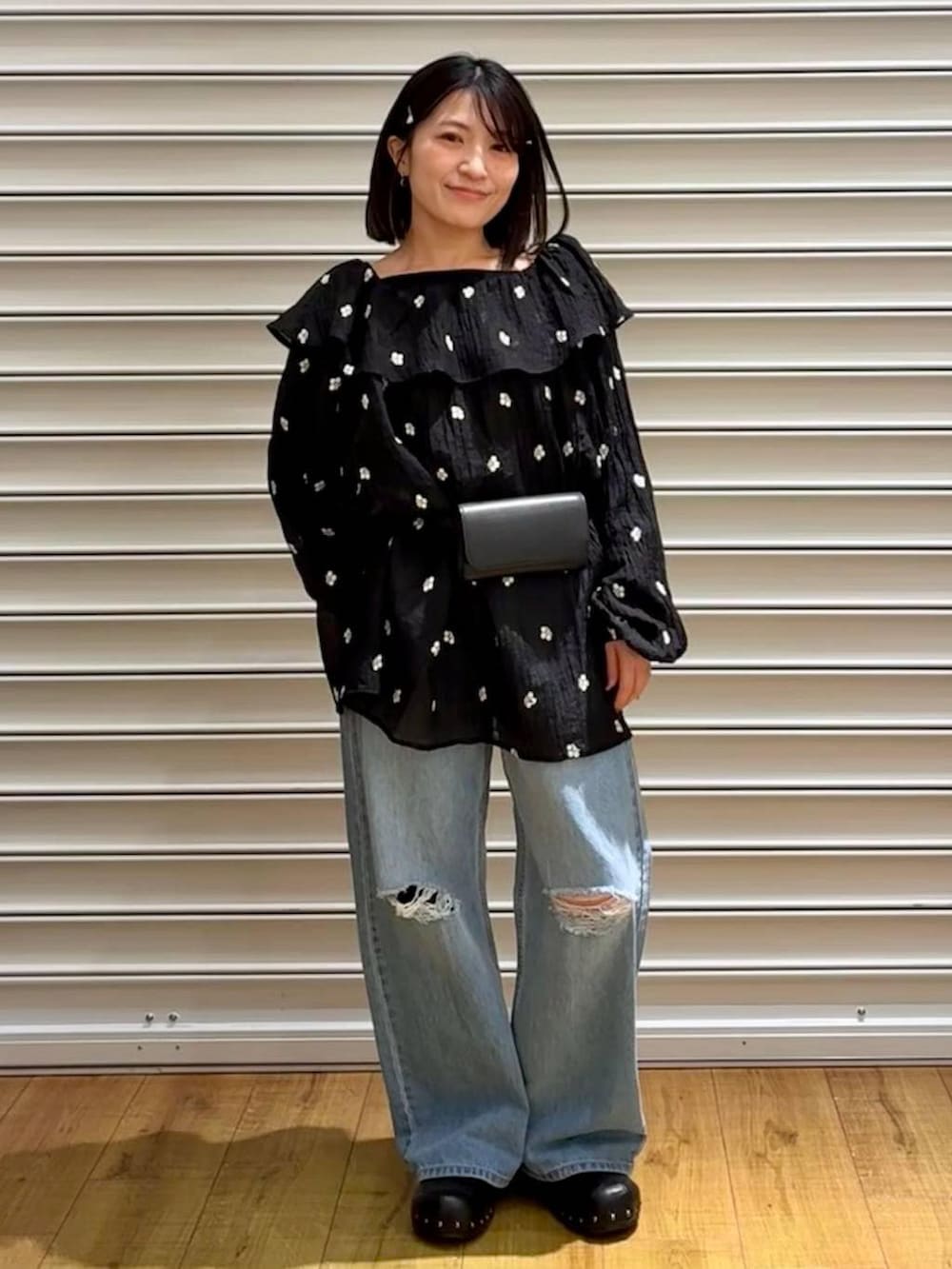 ブルー系のデニムパンツ、ブラック系のサンダル、ブラック系のボディバッグ/ウエストポーチを着用したレディースの春コーディネートの7枚目の写真