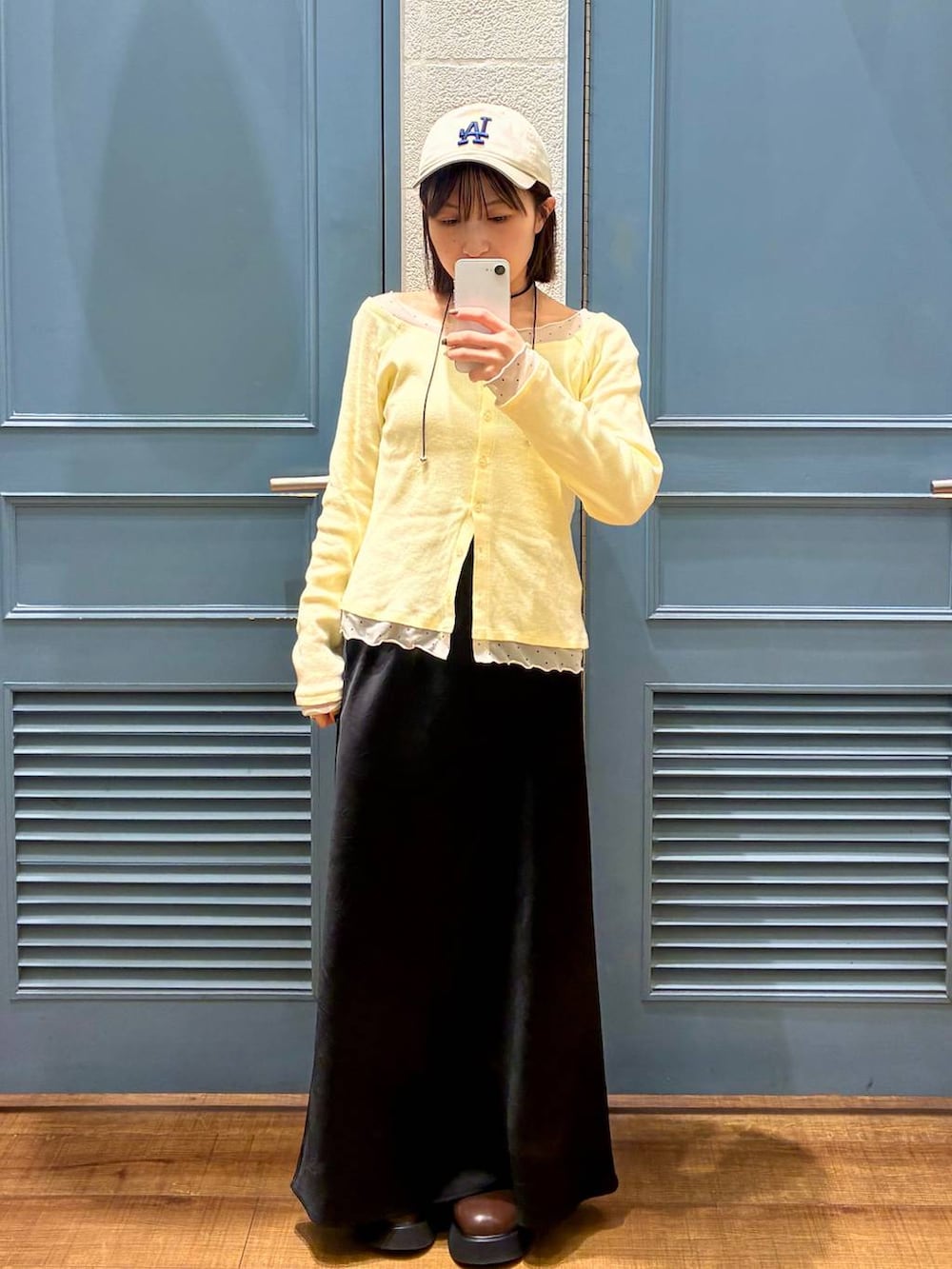 ブラック系のスカート、ブラウン系のサンダル、イエロー系のTシャツ/カットソーを着用したレディースの冬コーディネートの4枚目の写真