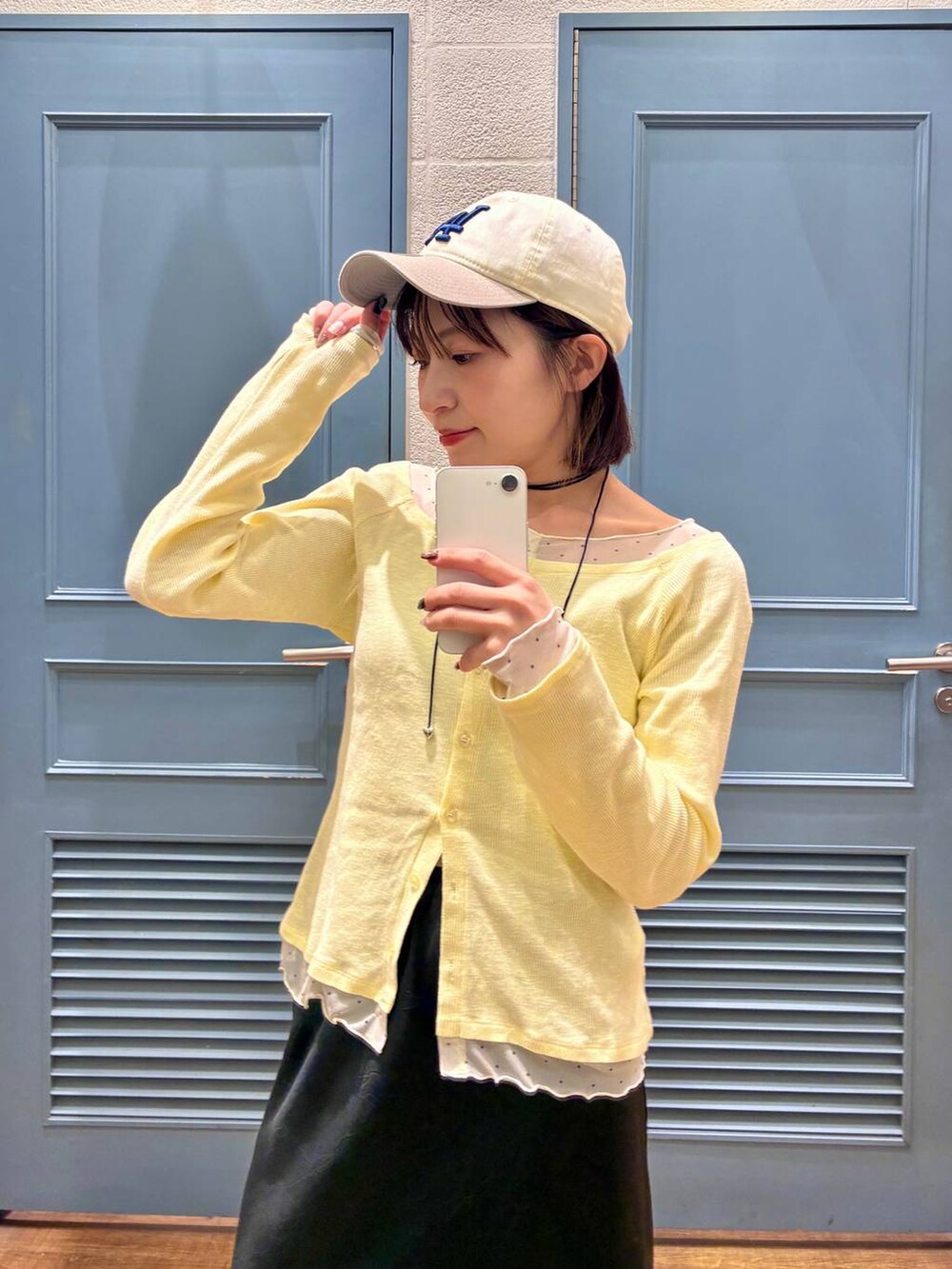 ブラック系のスカート、ブラウン系のサンダル、イエロー系のTシャツ/カットソーを着用したレディースの冬コーディネートの3枚目の写真