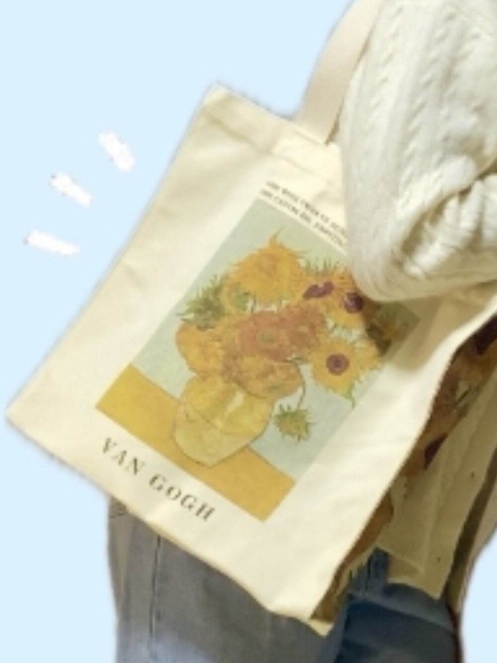 ホワイト系のニット/セーター、イエロー系のトートバッグ、ブルー系のデニムパンツを着用したレディースの冬コーディネートの2枚目の写真