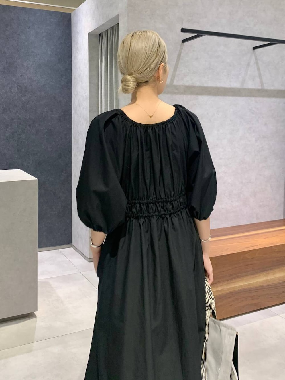 シルバー系のローファー、グレー系のトートバッグ、ブラック系のワンピースを着用したレディースの夏コーディネートの3枚目の写真