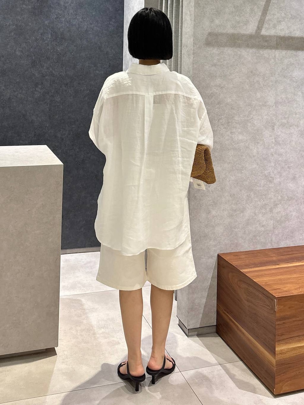 ブラウン系のトートバッグ、ブラック系のサンダル、ホワイト系のシャツ/ブラウスを着用したレディースの春コーディネートの4枚目の写真