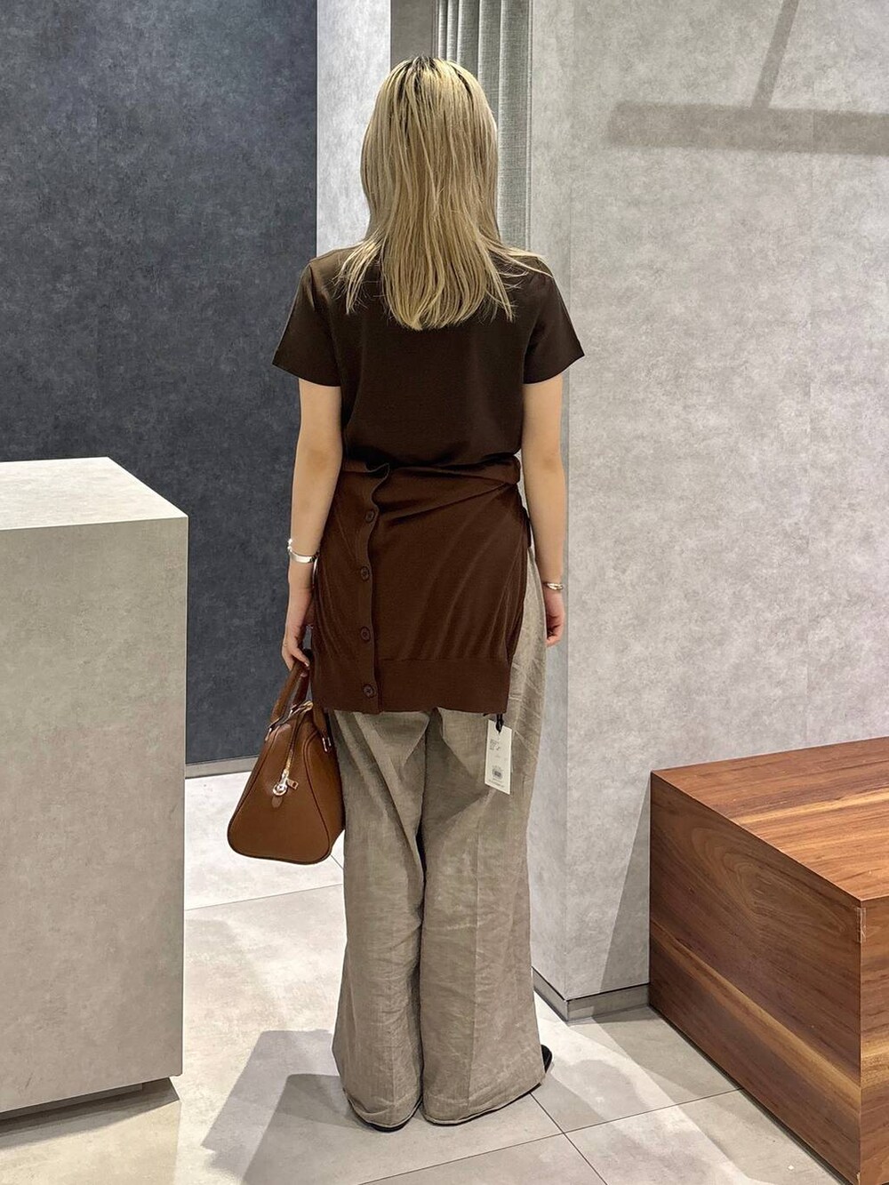 ブラウン系のボストンバッグ、ブラウン系のTシャツ/カットソー、ベージュ系のその他パンツを着用したレディースの春コーディネートの2枚目の写真