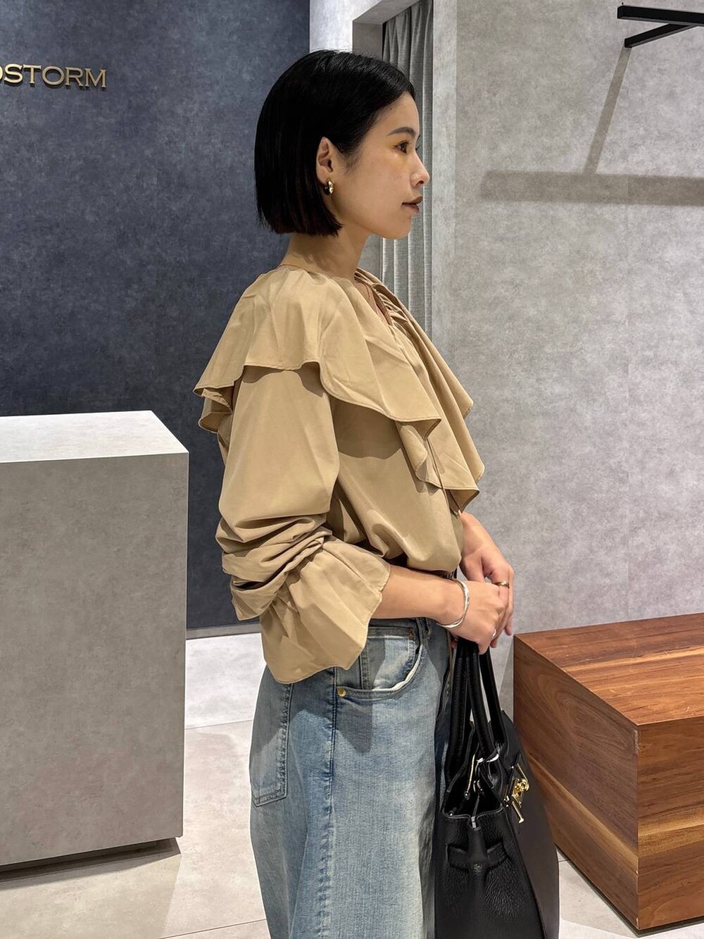 ブルー系のデニムパンツ、ブラック系のローファー、ブラック系のショルダーバッグを着用したレディースの夏コーディネートの6枚目の写真