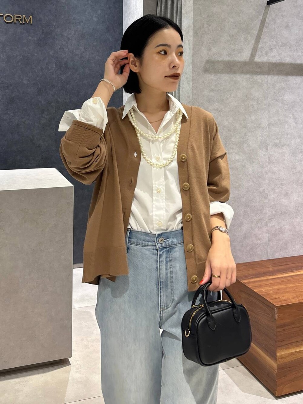 ブルー系のデニムパンツ、ブラック系のローファー、ホワイト系のシャツ/ブラウスを着用したレディースの夏コーディネートの5枚目の写真