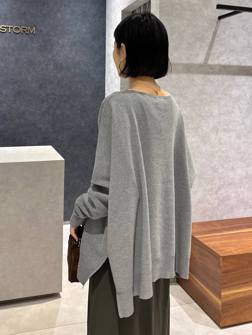 グリーン系のスカート、ホワイト系のTシャツ/カットソー、ブラウン系のショルダーバッグを着用したレディースの夏コーディネートの7枚目の写真