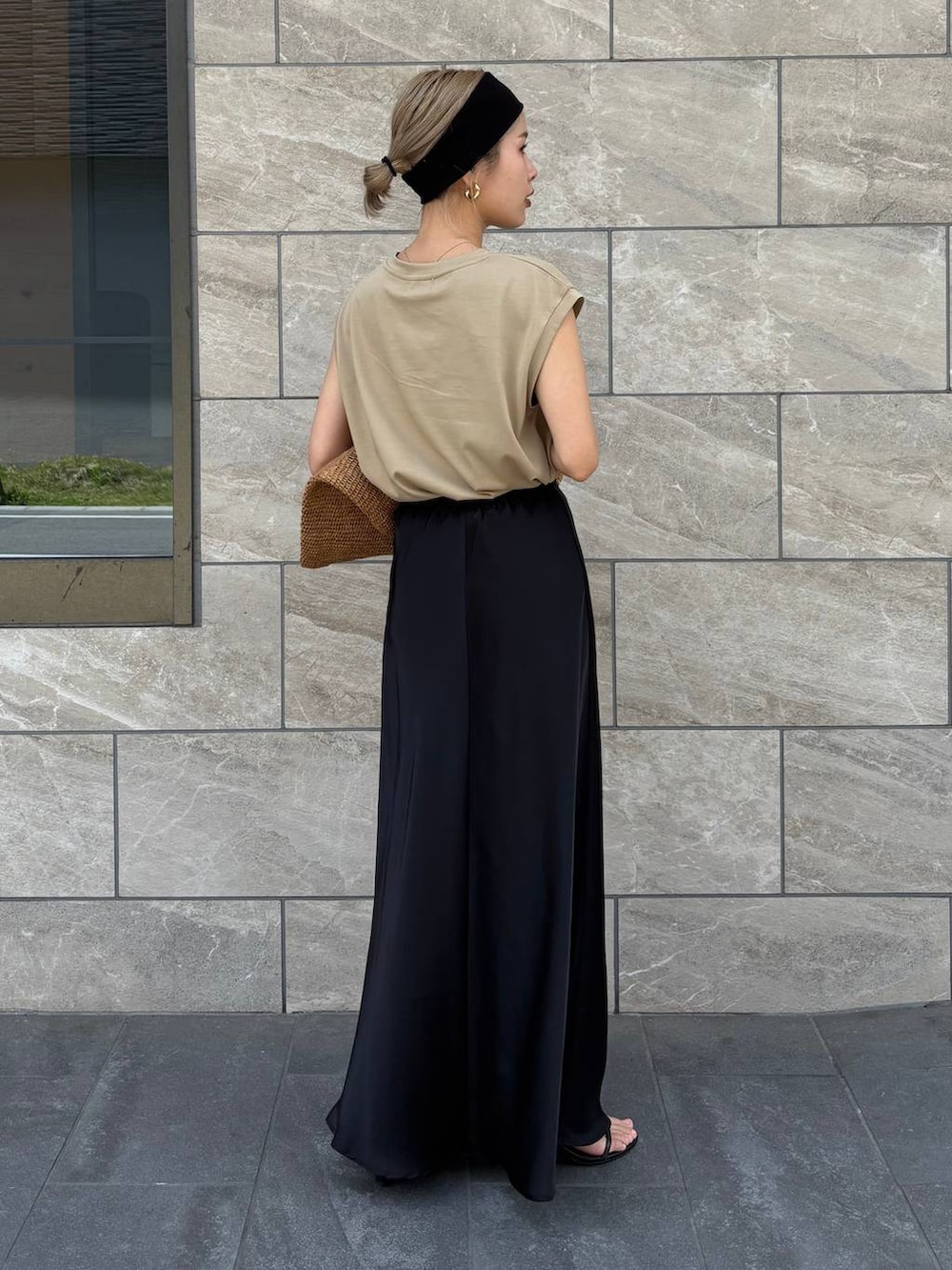 ブラウン系のトートバッグ、ベージュ系のTシャツ/カットソー、ブラック系のスカートを着用したレディースの春コーディネートの5枚目の写真