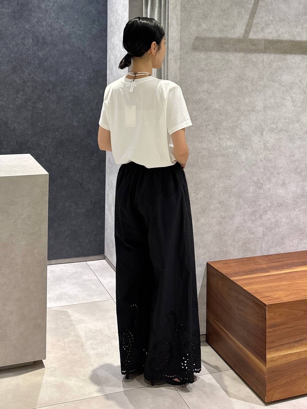 ブラック系のショルダーバッグ、ブラック系のサンダル、ホワイト系のTシャツ/カットソーを着用したレディースの夏コーディネートの3枚目の写真