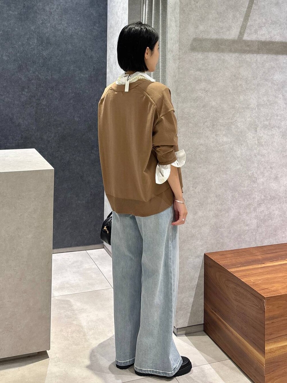 ブルー系のデニムパンツ、ブラック系のローファー、ホワイト系のシャツ/ブラウスを着用したレディースの夏コーディネートの3枚目の写真