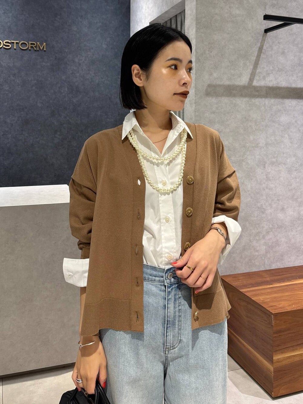 ブルー系のデニムパンツ、ブラック系のローファー、ホワイト系のシャツ/ブラウスを着用したレディースの夏コーディネートの6枚目の写真