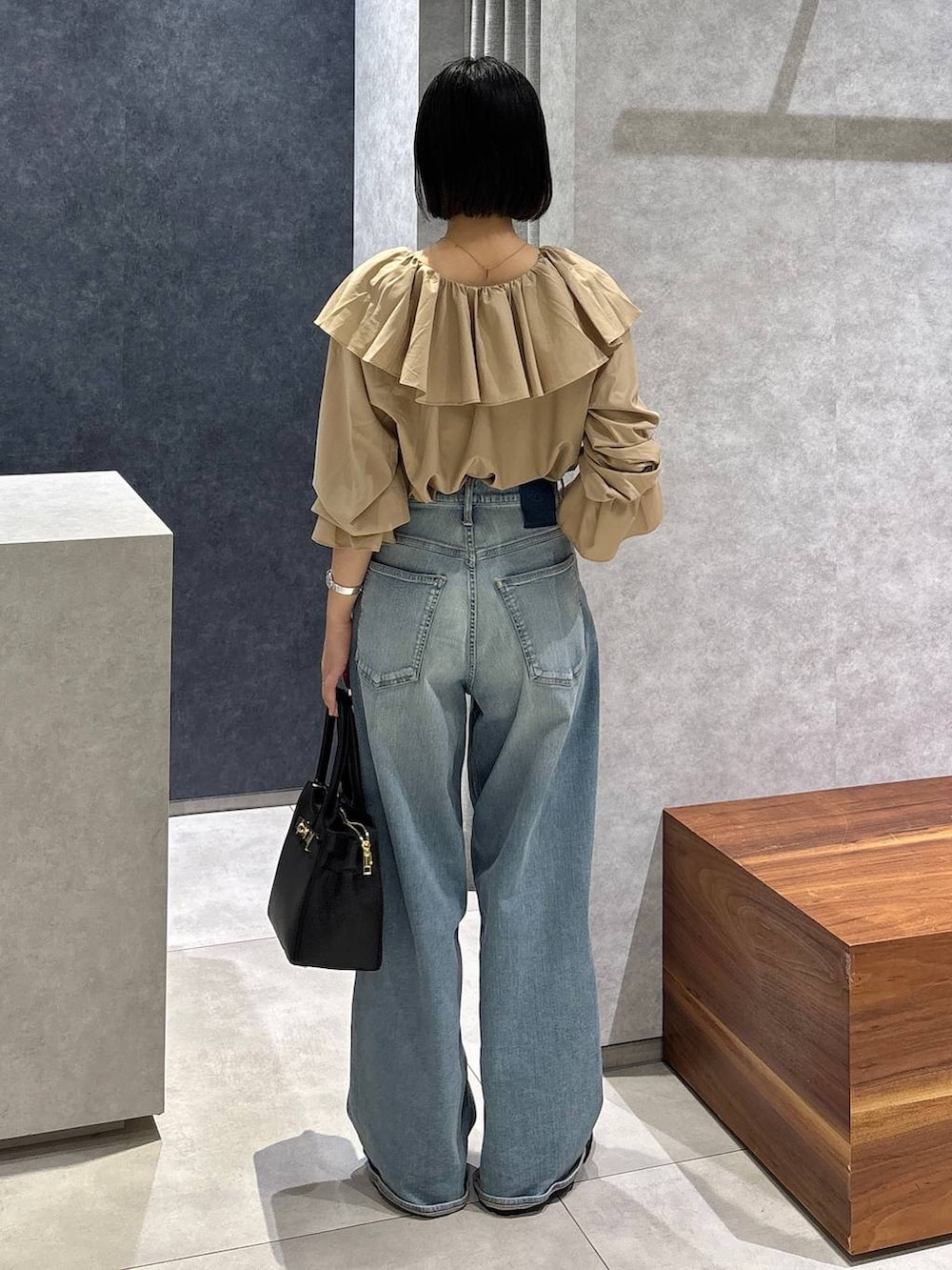 ブルー系のデニムパンツ、ブラック系のローファー、ブラック系のショルダーバッグを着用したレディースの夏コーディネートの4枚目の写真