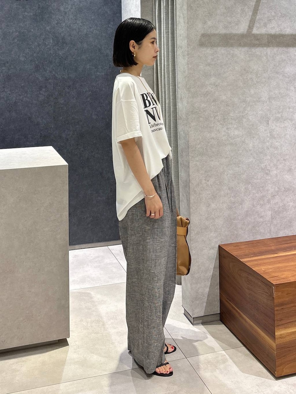 グレー系のその他パンツ、ブラック系のサンダル、イエロー系のショルダーバッグを着用したレディースの夏コーディネートの2枚目の写真