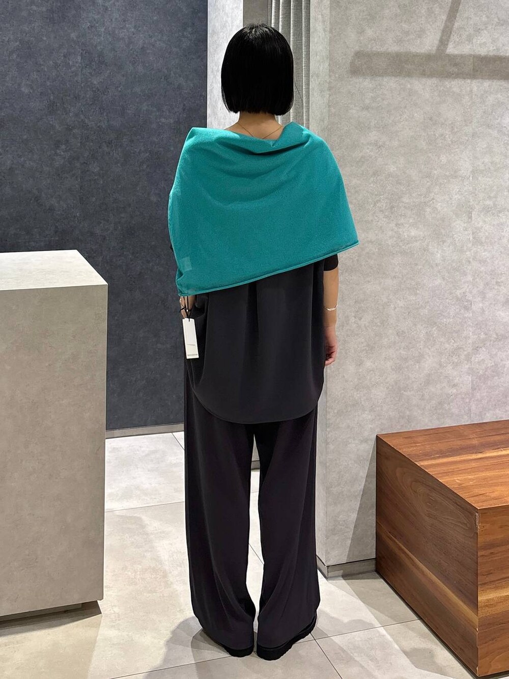 グレー系のシャツ/ブラウス、グレー系のスラックス、グリーン系のニット/セーターを着用したレディースの夏コーディネートの4枚目の写真