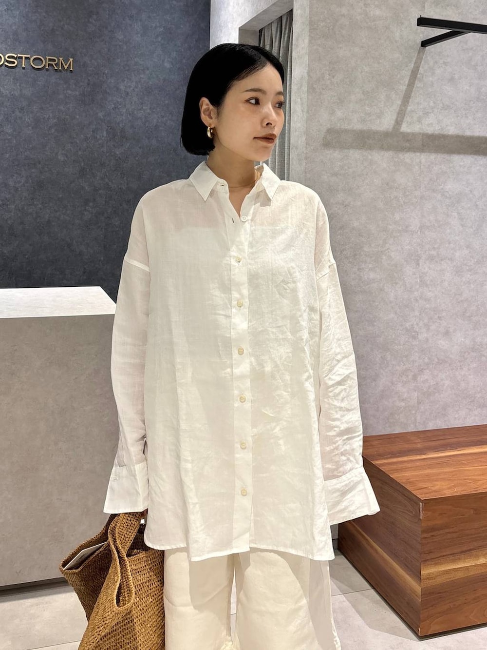 ブラウン系のトートバッグ、ブラック系のサンダル、ホワイト系のシャツ/ブラウスを着用したレディースの春コーディネートの5枚目の写真