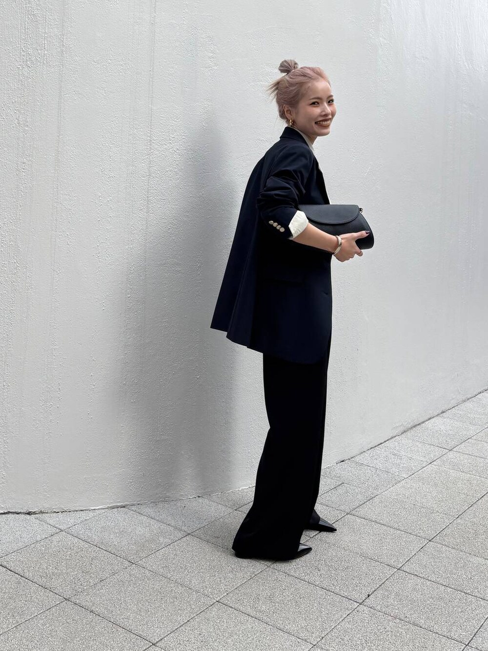 ブラック系のショルダーバッグ、ブラック系のスラックス、ブルー系のテーラードジャケットを着用したレディースの冬コーディネートの5枚目の写真