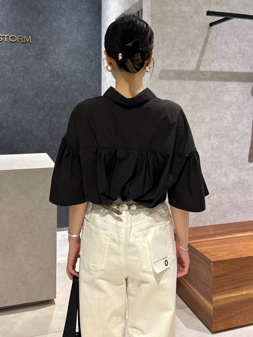 ホワイト系のデニムパンツ、ブラック系のサンダル、ブラック系のハンドバッグを着用したレディースの夏コーディネートの5枚目の写真