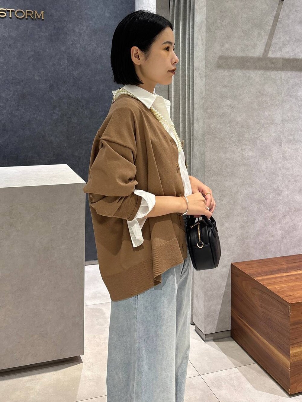 ブルー系のデニムパンツ、ブラック系のローファー、ホワイト系のシャツ/ブラウスを着用したレディースの夏コーディネートの7枚目の写真