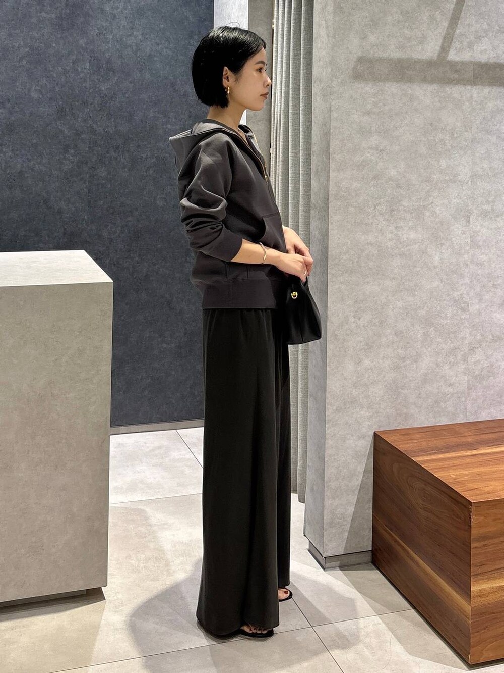 ブラック系のハンドバッグ、グリーン系のタンクトップ、グリーン系のスカートを着用したレディースの夏コーディネートの2枚目の写真