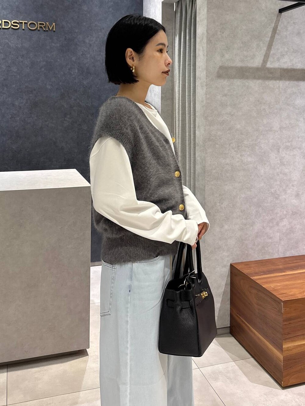 ブラック系のショルダーバッグ、ブルー系のデニムパンツ、ホワイト系のTシャツ/カットソーを着用したレディースの夏コーディネートの5枚目の写真